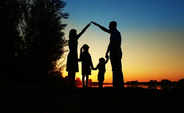depositphotos_137165198-stock-photo-silhouette-of-happy-family-holding